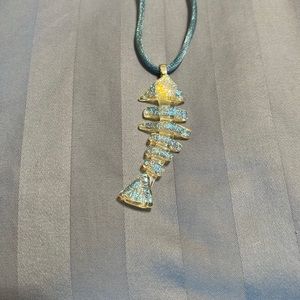 Iridescent fused glass fish on silk cord.